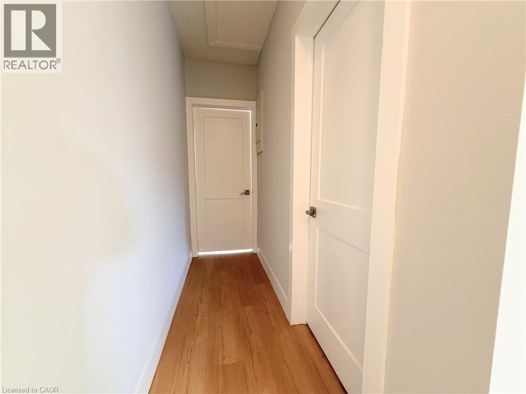 Hallway featuring light wood-finish flooring and white walls - 310 Barton Street E Unit# A, Hamilton, ON - Indoor Photo Showing Other Room