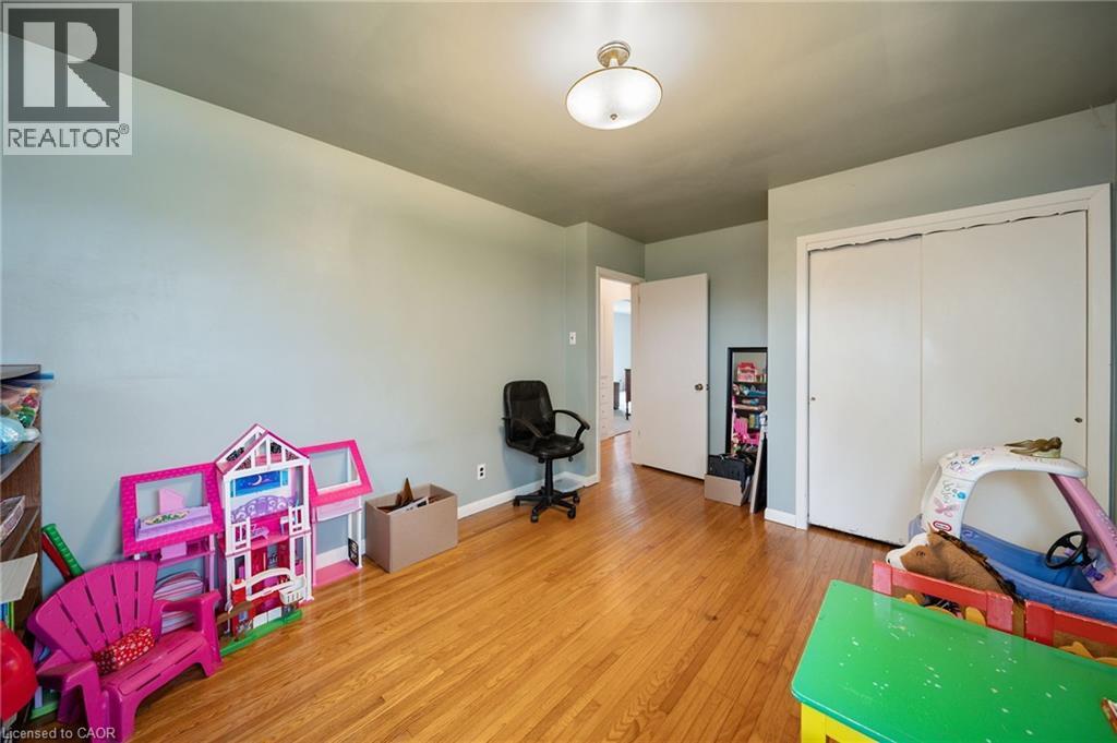 Bright room featuring wood-finish flooring, light-toned walls, and a ceiling-mounted light fixture - 2223 Hall Road, Binbrook, ON - Indoor
