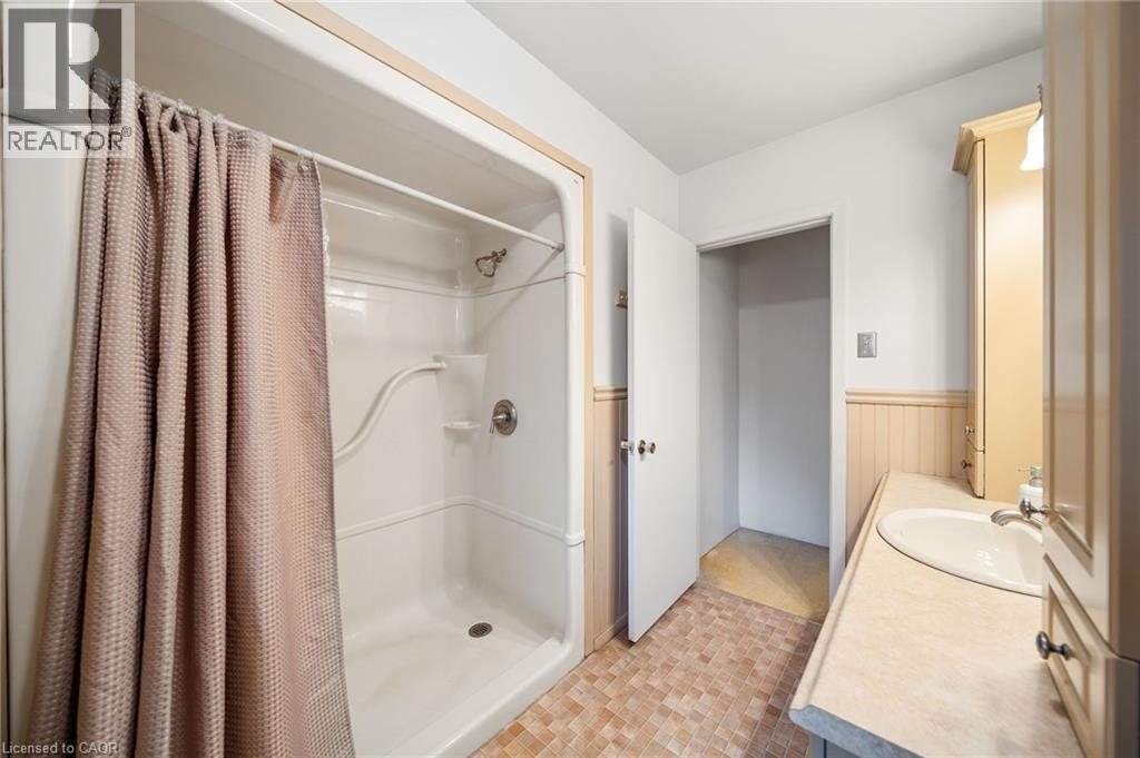 Bathroom featuring a shower stall, a single vanity with an integrated sink, and light-toned cabinetry - 2223 Hall Road, Binbrook, ON - Indoor Photo Showing Bathroom