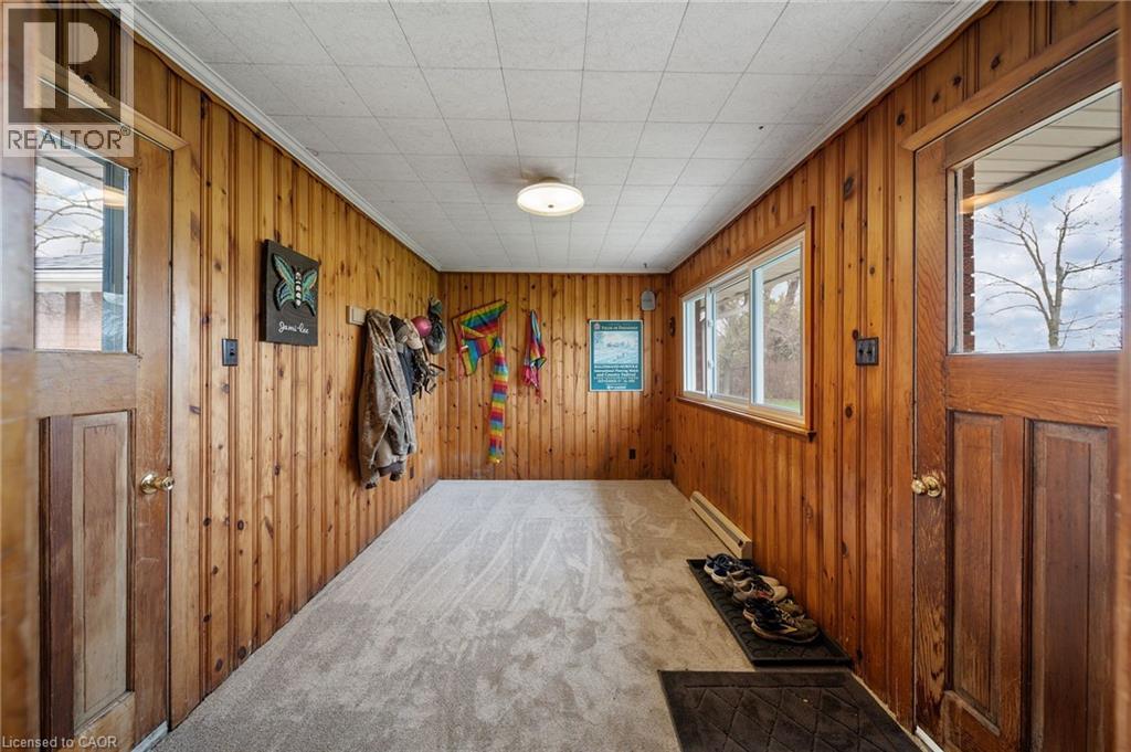 Paneled entry featuring light-toned carpeting and wood doors with glass inserts - 2223 Hall Road, Binbrook, ON - Indoor Photo Showing Other Room