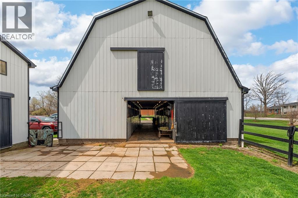 Gambrel-roof barn with white vertical siding and black trim - 2223 Hall Road, Binbrook, ON - Outdoor With Exterior