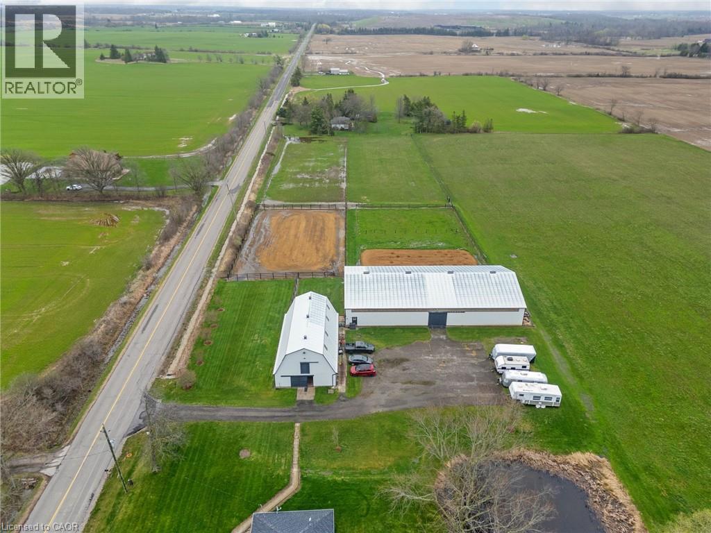 Expansive rural property featuring multiple outbuildings, including a large white barn with a silver roof - 2223 Hall Road, Binbrook, ON - Outdoor With View