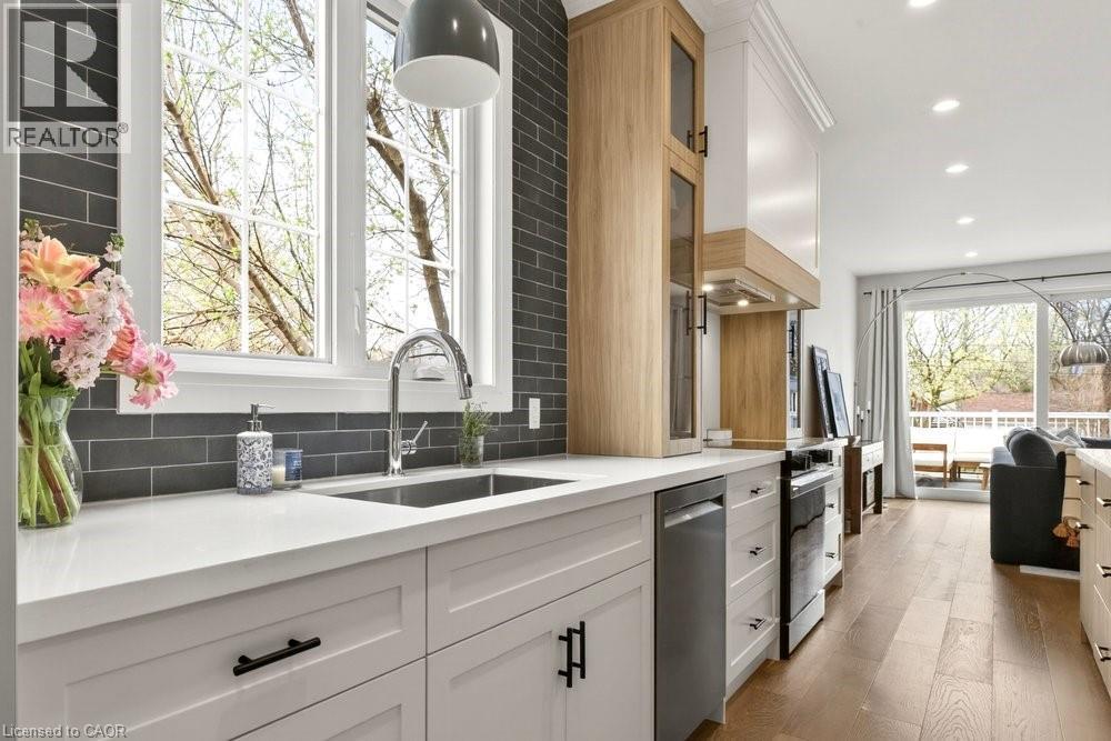 Bright kitchen featuring white shaker cabinetry, stainless steel sink, and light countertops - 128 Canada Street, Hamilton, ON - Indoor Photo Showing Kitchen With Upgraded Kitchen