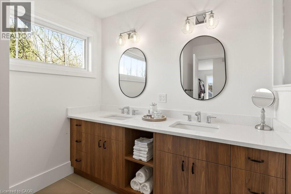 Dual vanity featuring wood-finish cabinetry and white countertops - 128 Canada Street, Hamilton, ON - Indoor Photo Showing Bathroom