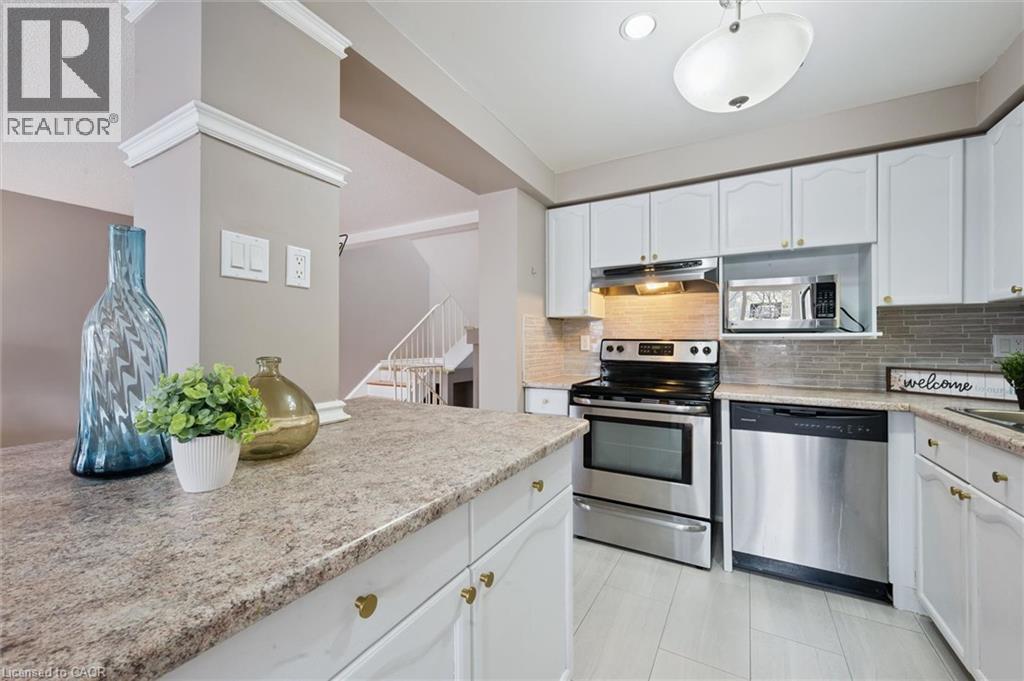 Kitchen featuring white cabinetry, light-colored countertops, and stainless steel appliances - 365 Pioneer Drive Unit# 25, Kitchener, ON - Indoor Photo Showing Kitchen