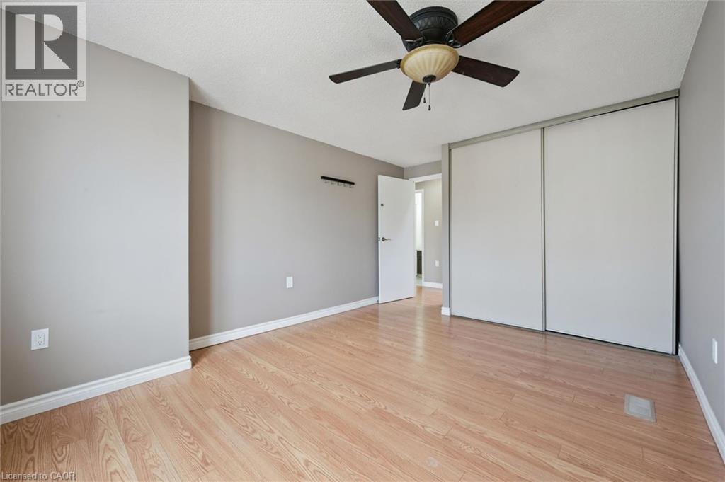 Room featuring wood-finish flooring, light grey walls, white baseboards, and a ceiling fan with integrated lighting - 365 Pioneer Drive Unit# 25, Kitchener, ON - Indoor Photo Showing Other Room