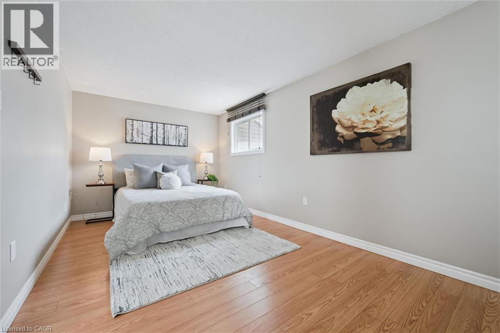 Bedroom featuring wood-finish flooring, neutral wall tones, and white baseboards - 365 Pioneer Drive Unit# 25, Kitchener, ON - Indoor Photo Showing Bedroom