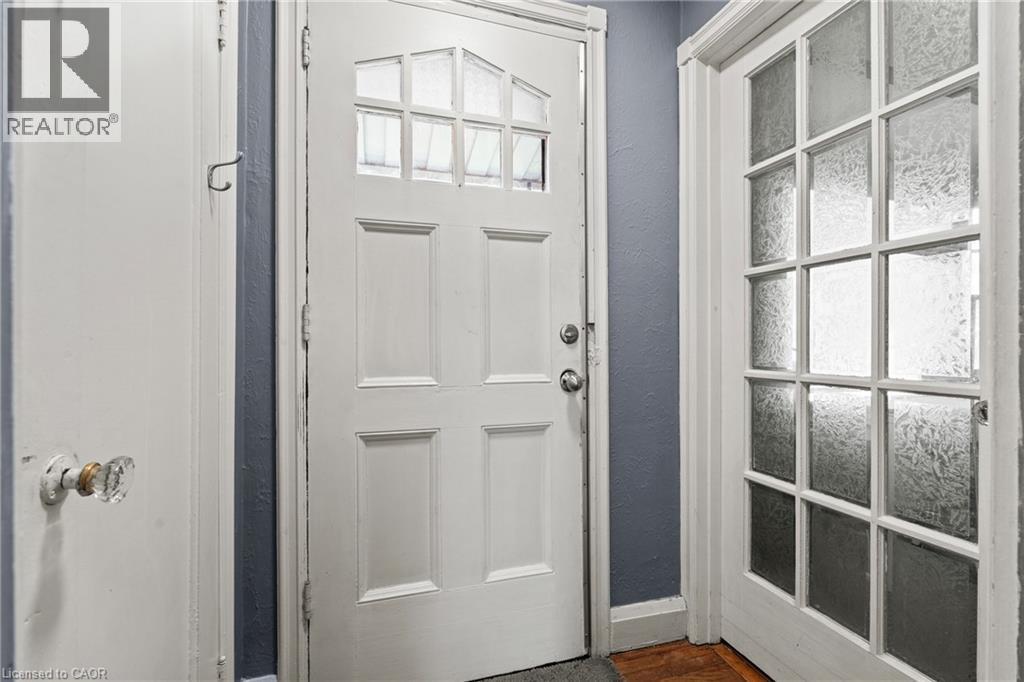 White paneled door with upper glass inserts, accompanied by a multi-paneled door featuring frosted glass - 25 East 39Th Street, Hamilton, ON - Indoor Photo Showing Other Room