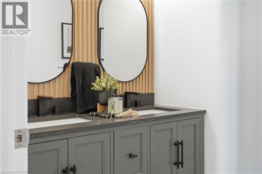 Dual vanity with integrated sinks and dark stone countertops - 47 Winners Way, Binbrook, ON - Indoor Photo Showing Bathroom