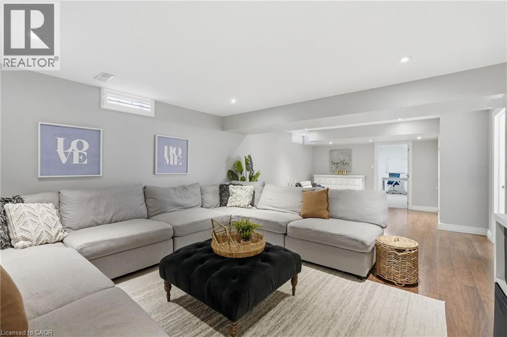 Finished lower level with recessed lighting, wood-finish flooring, and light gray wall tones - 47 Winners Way, Binbrook, ON - Indoor Photo Showing Living Room