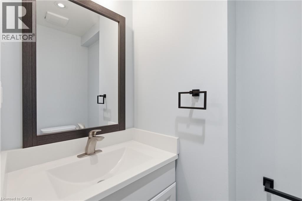 Modern bathroom vanity featuring a white countertop, undermount sink, and a brushed nickel faucet - 149 Lottridge Street, Hamilton, ON - Indoor Photo Showing Bathroom