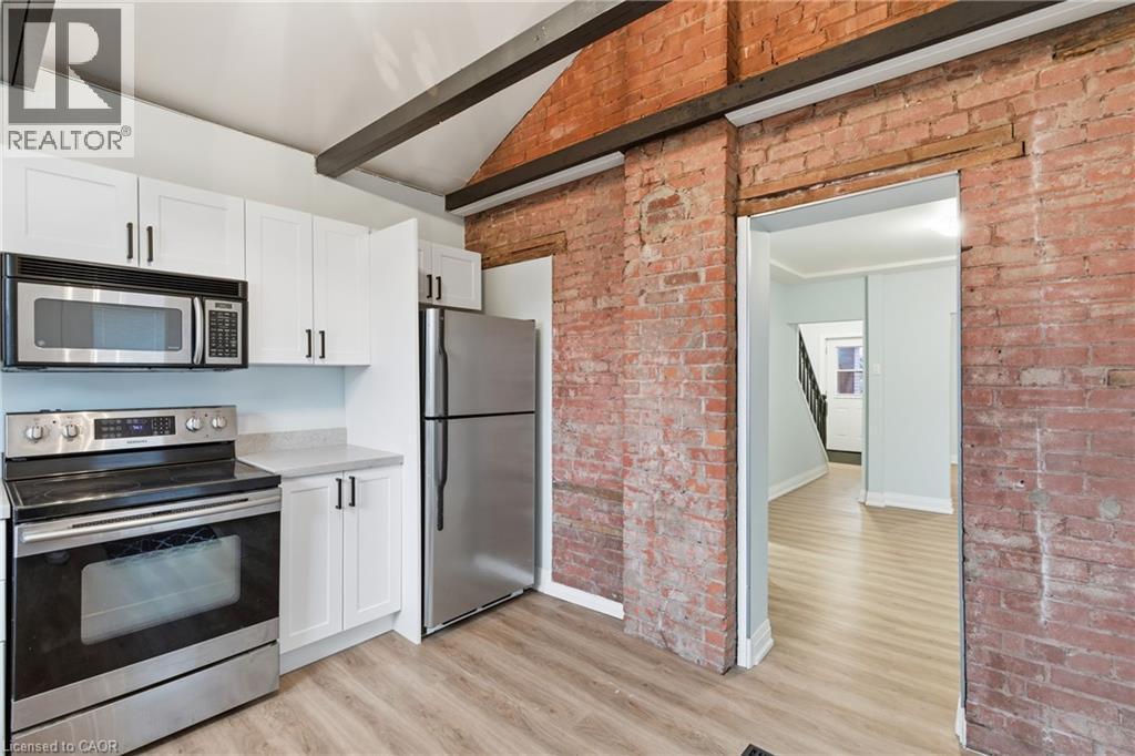 Kitchen featuring a stainless steel appliance suite, white cabinetry with black hardware, and light-toned countertops - 149 Lottridge Street, Hamilton, ON - Indoor Photo Showing Kitchen With Stainless Steel Kitchen