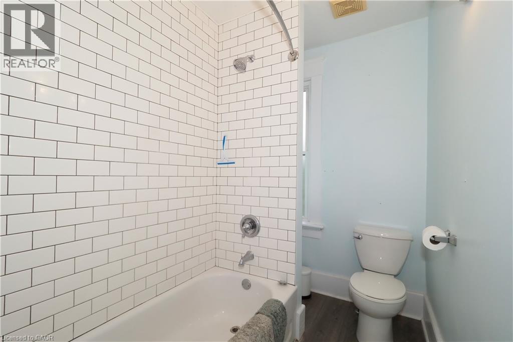 White subway tile shower surround with a built-in tub and chrome fixtures - 205 Duke Street E, Kitchener, ON - Indoor Photo Showing Bathroom