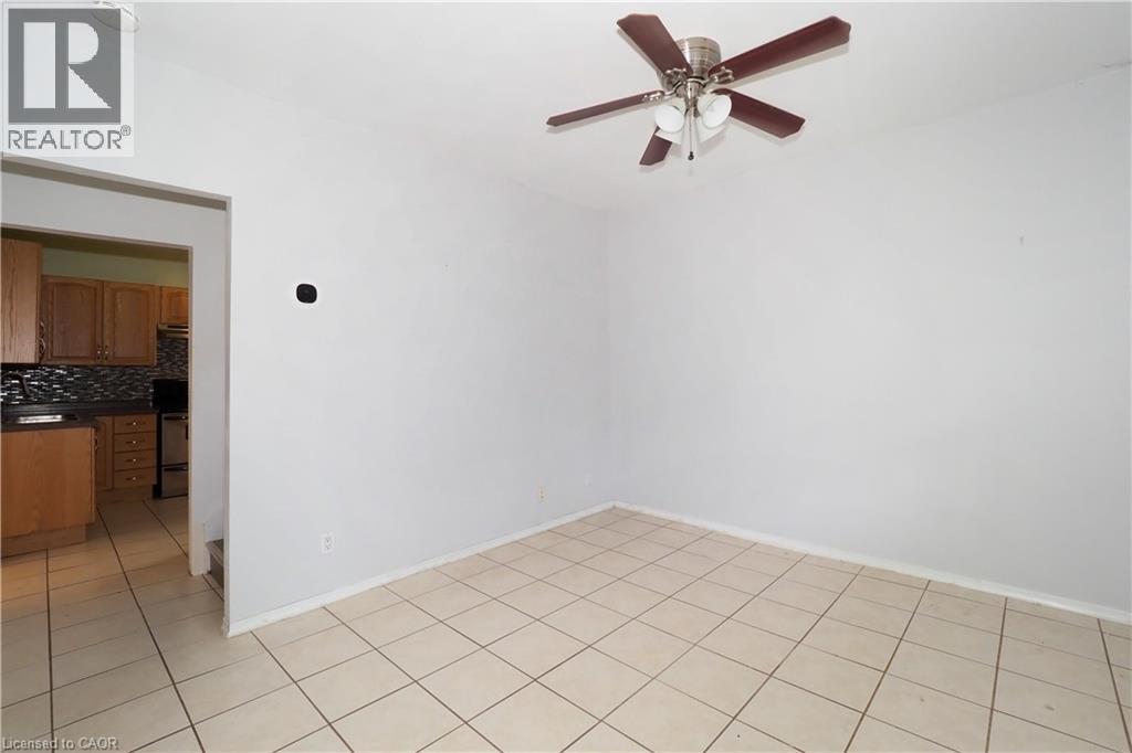 Tiled flooring extends throughout this interior space, featuring a ceiling fan with integrated lighting - 205 Duke Street E, Kitchener, ON - Indoor Photo Showing Other Room