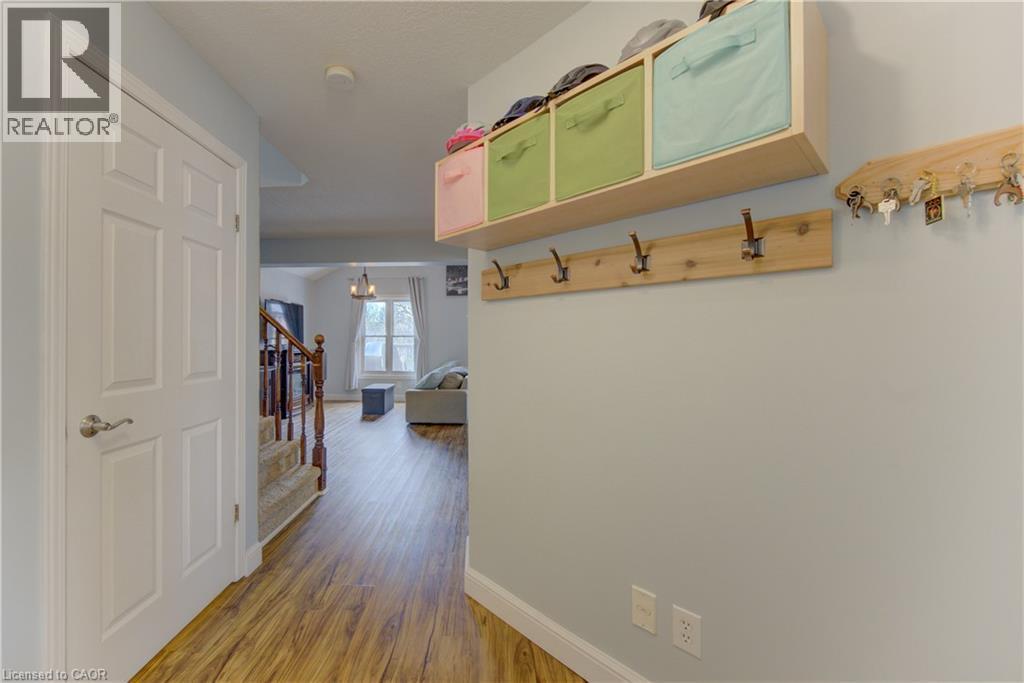 Entryway featuring wood-finish flooring, a six-panel interior door, and a staircase with a wooden handrail and carpeted treads - 512 Hidden Creek Drive, Kitchener, ON - Indoor Photo Showing Other Room