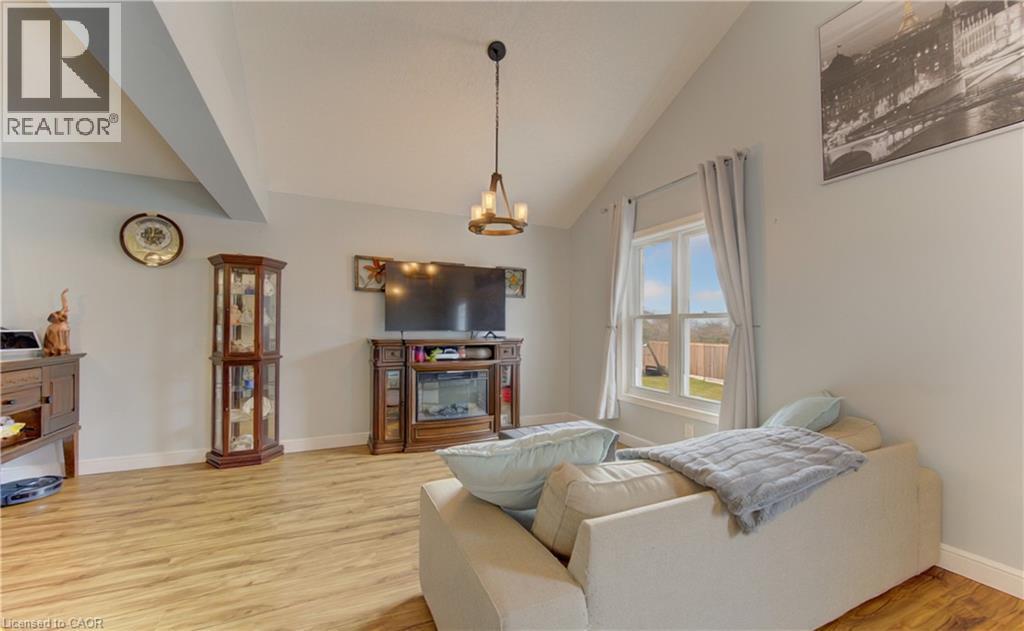 Vaulted ceiling with exposed beam, wood-finish flooring, and light-toned wall paint - 512 Hidden Creek Drive, Kitchener, ON - Indoor Photo Showing Living Room