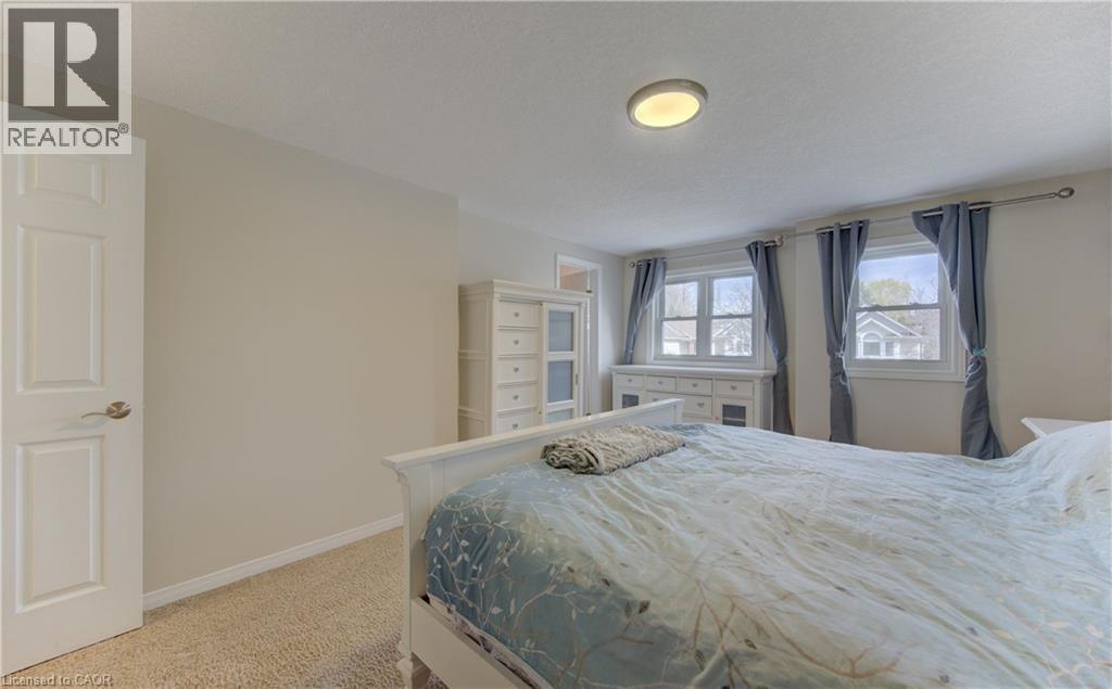 Carpeted bedroom with neutral wall tones and a white interior door - 512 Hidden Creek Drive, Kitchener, ON - Indoor Photo Showing Bedroom