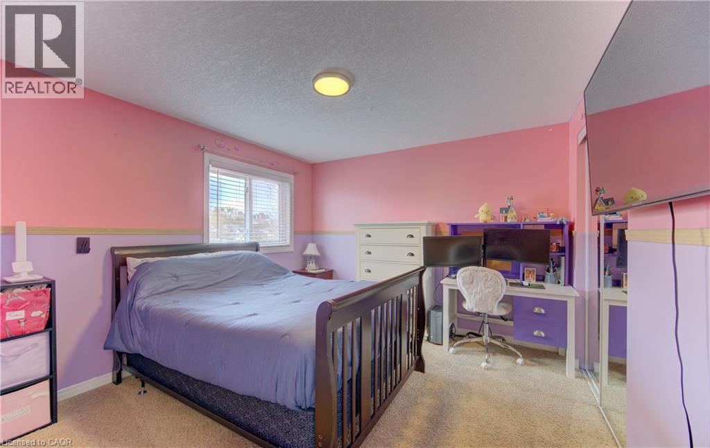 Carpeted room featuring a window with white blinds, a ceiling-mounted light fixture, and a built-in mirrored closet door - 512 Hidden Creek Drive, Kitchener, ON - Indoor Photo Showing Bedroom