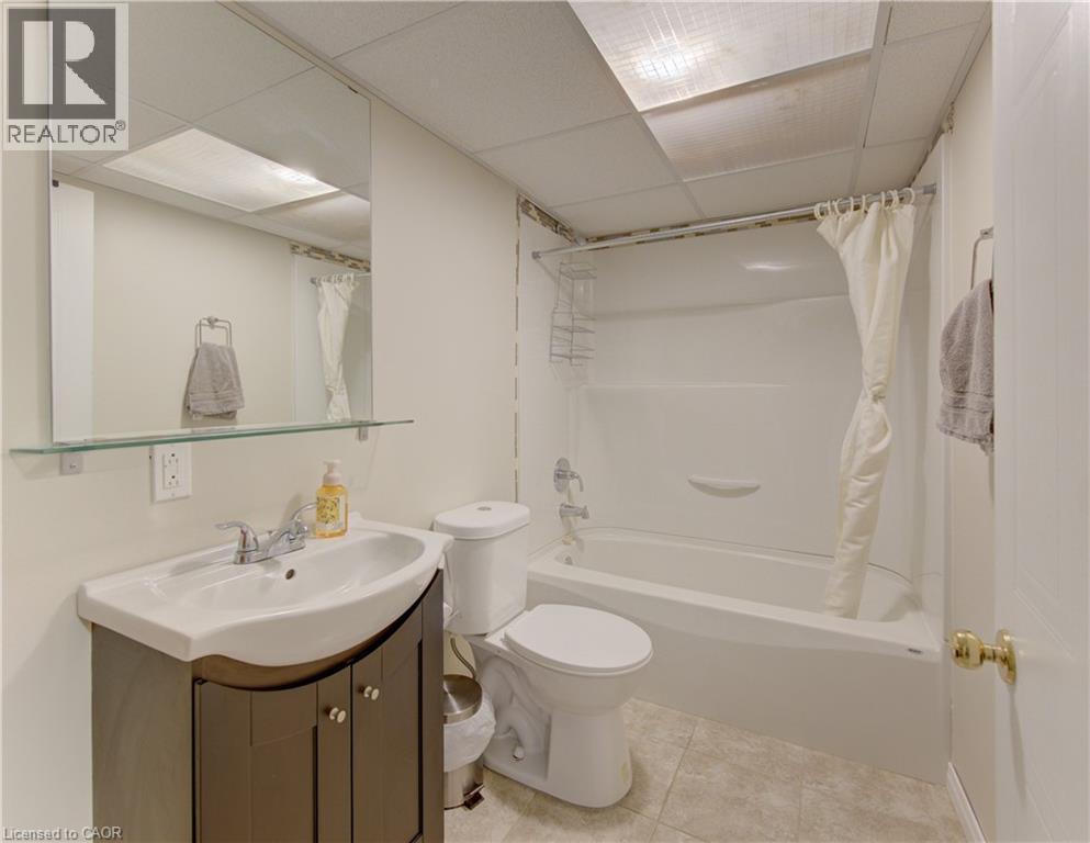 Full bathroom featuring a white bathtub/shower combination, a toilet, and a vanity with an integrated sink - 512 Hidden Creek Drive, Kitchener, ON - Indoor Photo Showing Bathroom