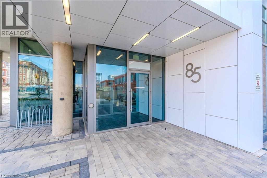 Contemporary building entrance featuring large pane windows and a glass entry door - 85 Duke Street W Unit# 507, Kitchener, ON - Outdoor With Exterior