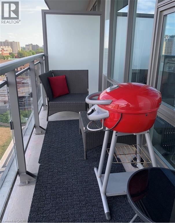 Balcony featuring concrete flooring, a glass and metal railing, and a frosted privacy panel - 85 Duke Street W Unit# 507, Kitchener, ON - Outdoor With Balcony With Exterior