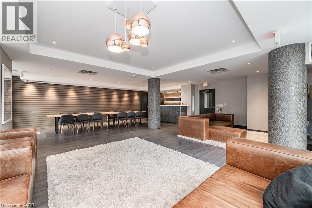 Open concept common area featuring wood-finish flooring, recessed lighting, and a textured accent wall - 85 Duke Street W Unit# 507, Kitchener, ON - Indoor