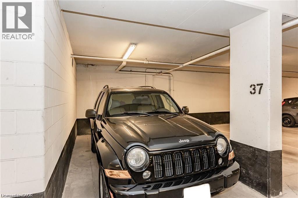 Designated parking space with concrete flooring and perimeter walls - 85 Duke Street W Unit# 507, Kitchener, ON - Indoor Photo Showing Garage