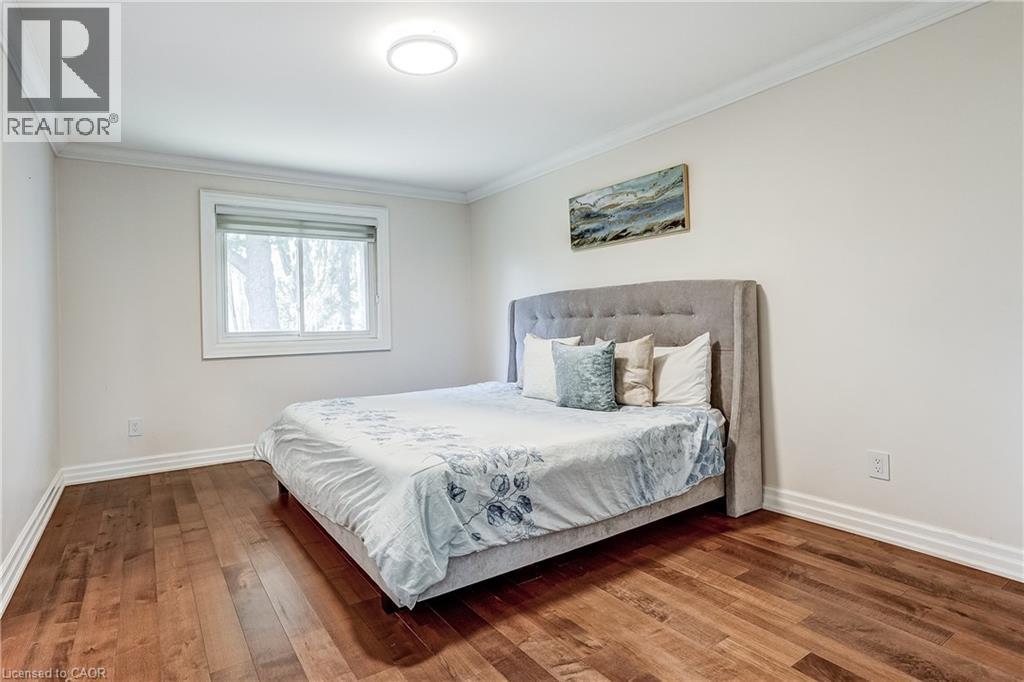 Bedroom featuring wood-finish flooring, a contemporary flush-mount ceiling light, white baseboards, and crown molding - 1264 Kane Road, Mississauga, ON - Indoor Photo Showing Bedroom