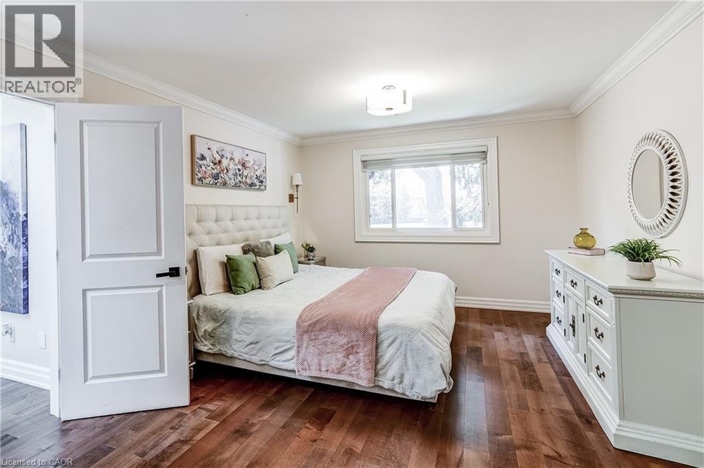 Bedroom featuring wood-finish flooring, a contemporary ceiling light fixture, a window with a roller shade, and crown molding - 1264 Kane Road, Mississauga, ON - Indoor Photo Showing Bedroom