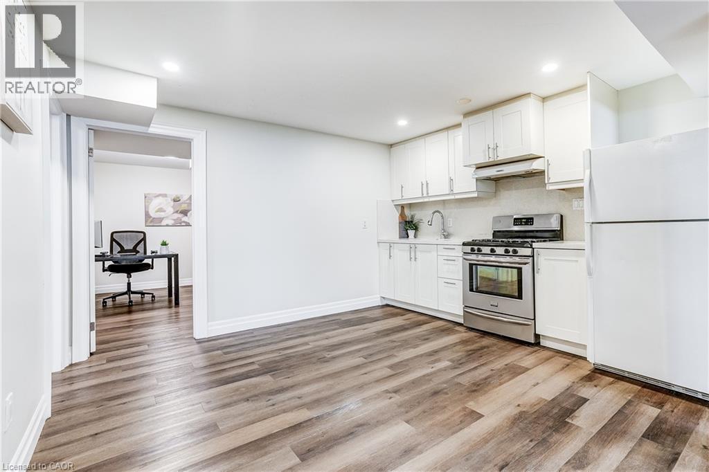 Kitchenette featuring white cabinetry, stainless steel range, white refrigerator, and wood-finish flooring - 1264 Kane Road, Mississauga, ON - Indoor Photo Showing Kitchen