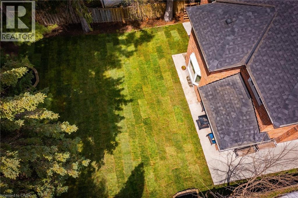 Expansive backyard featuring a manicured lawn, established perimeter fencing, and mature evergreen trees - 1264 Kane Road, Mississauga, ON - Outdoor With Deck Patio Veranda
