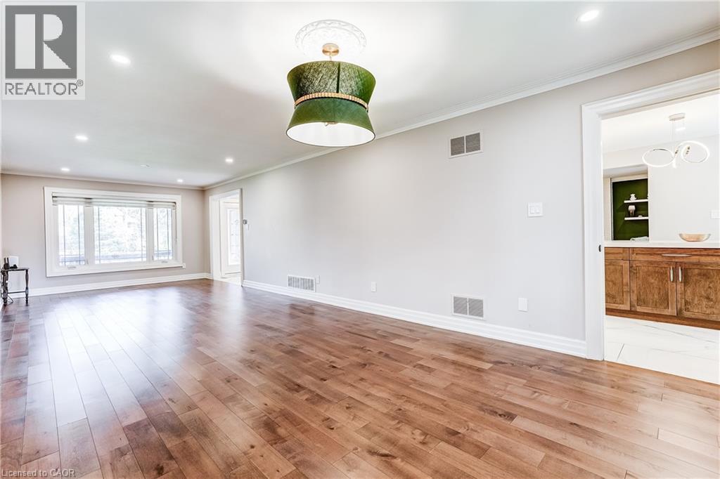 Spacious room with wood-finish flooring, recessed lighting, and a prominent bay window - 1264 Kane Road, Mississauga, ON - Indoor Photo Showing Other Room