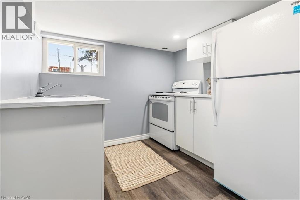 Basement kitchen with double sink, stove & full-size fridge - 29 Wexford Avenue N, Hamilton, ON - Indoor