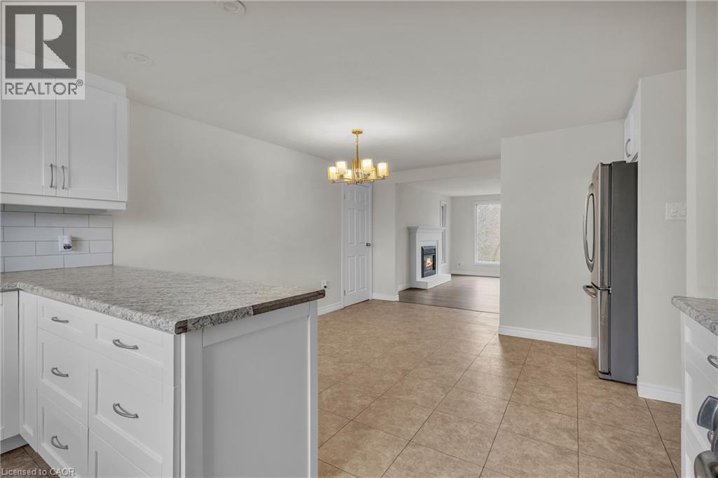 Open-concept kitchen with white shaker cabinetry, light-toned countertops, and subway tile backsplash - 22 Blackhorne Crescent, Kitchener, ON - Indoor Photo Showing Kitchen