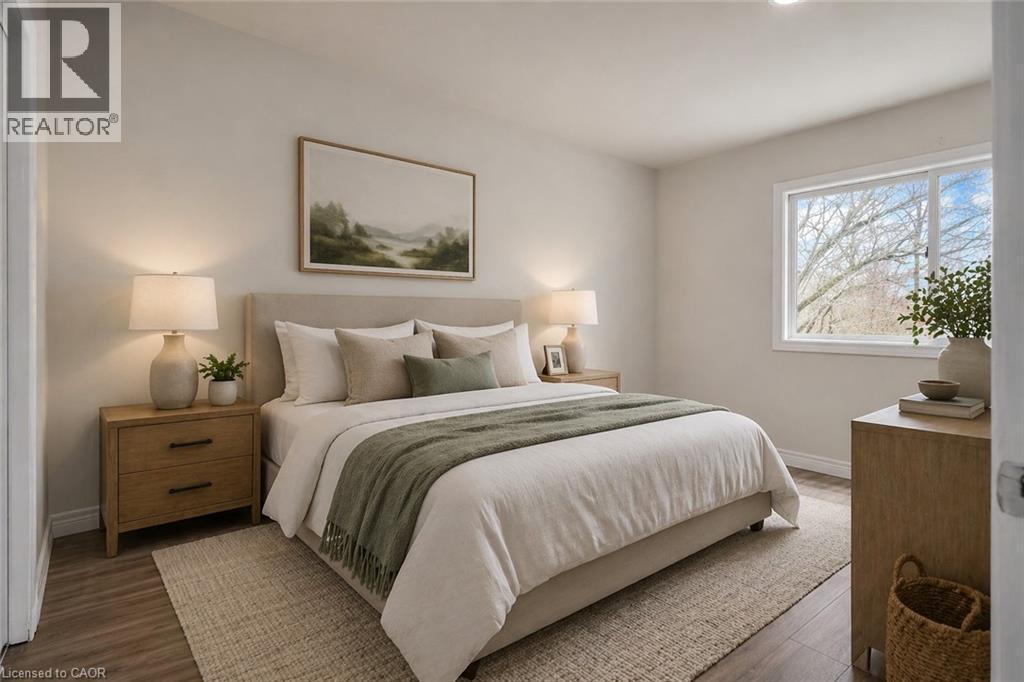 Spacious room featuring wood-finish flooring, light neutral wall tones, and a large window - 22 Blackhorne Crescent, Kitchener, ON - Indoor Photo Showing Bedroom