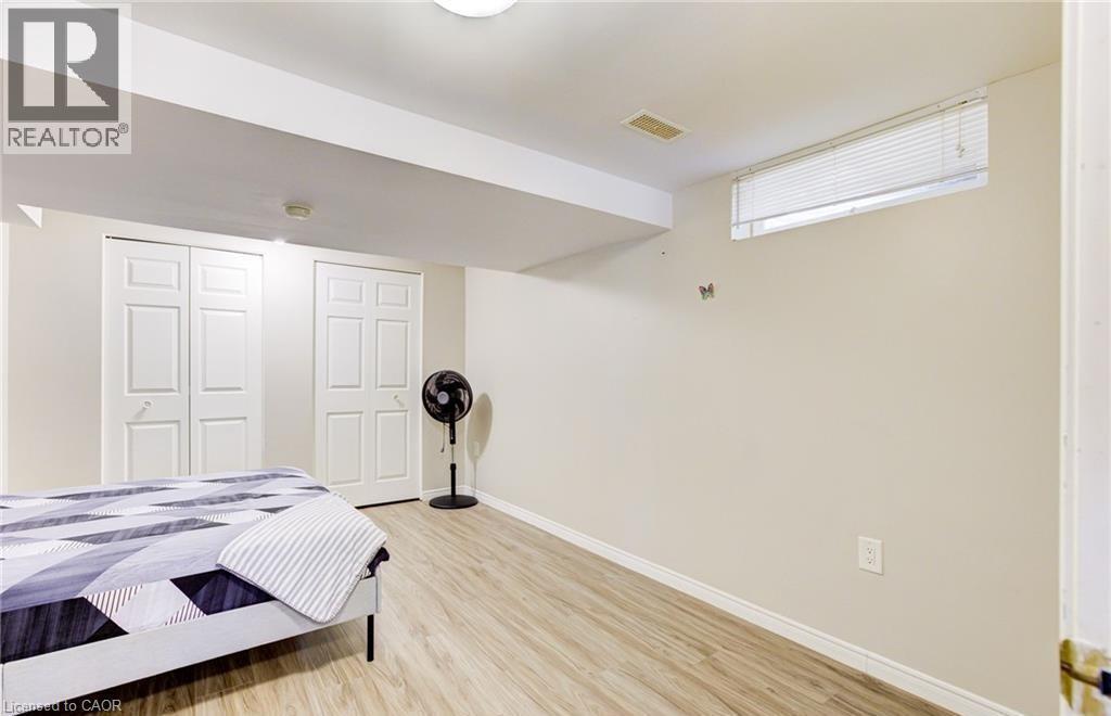 Room featuring wood-finish flooring, light-toned walls, and a recessed window with blinds - 22 Blackhorne Crescent, Kitchener, ON - Indoor Photo Showing Bedroom