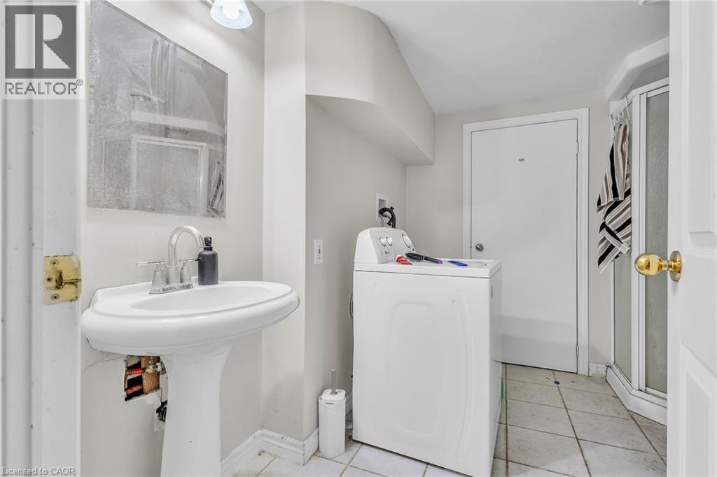 Bathroom featuring a pedestal sink with a chrome faucet, wall-mounted mirror, and tile flooring - 22 Blackhorne Crescent, Kitchener, ON - Indoor