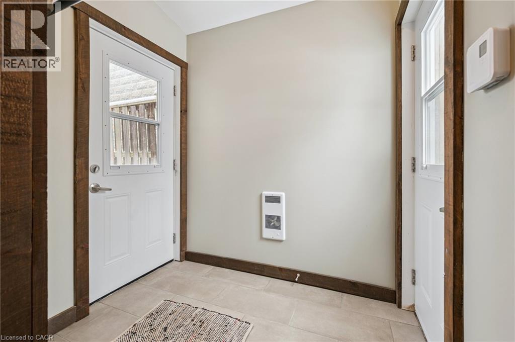 Entryway featuring a white paneled door with integrated window and rustic wood-finish trim - 838 Moore Street, Cambridge, ON - Indoor Photo Showing Other Room