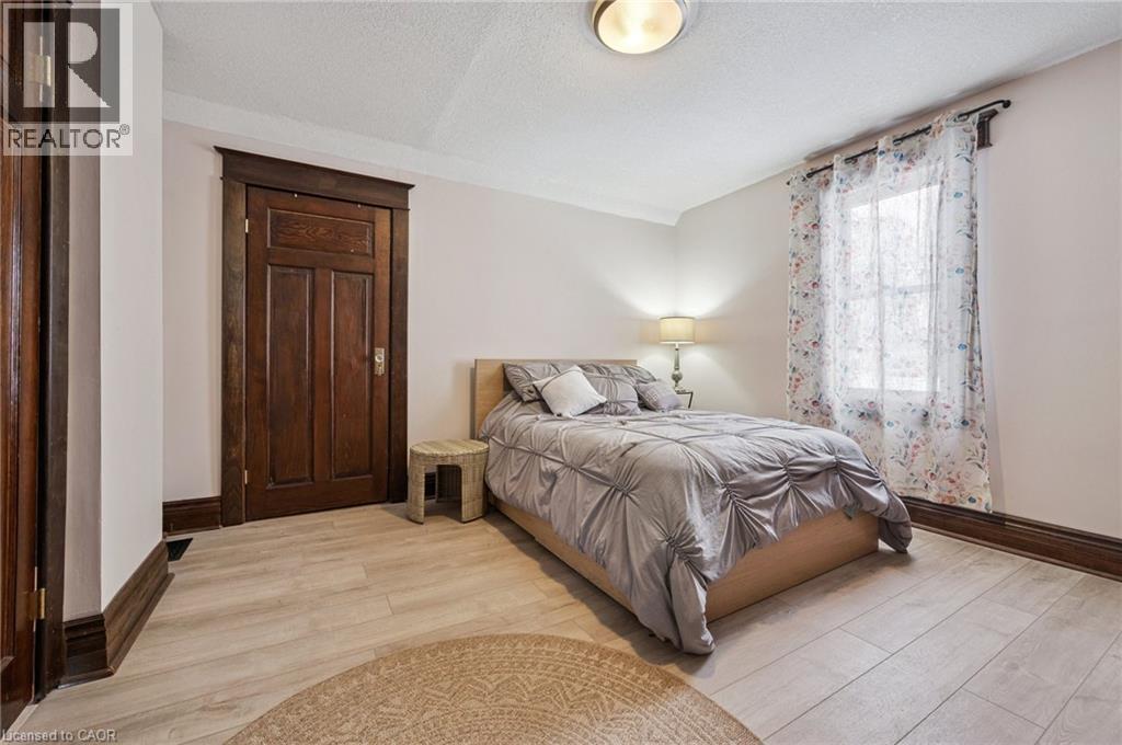 Room featuring light-toned wood-finish flooring, a window with natural light, and a ceiling-mounted light fixture - 838 Moore Street, Cambridge, ON - Indoor Photo Showing Bedroom