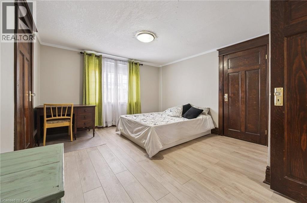 Light wood-finish flooring complements the neutral wall color in this space - 838 Moore Street, Cambridge, ON - Indoor Photo Showing Bedroom