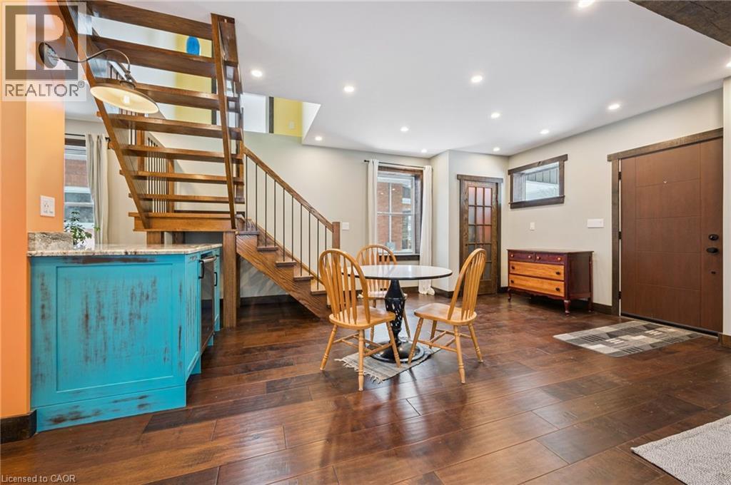 Rich wood-finish flooring complements the open-tread staircase with metal balusters - 838 Moore Street, Cambridge, ON - Indoor