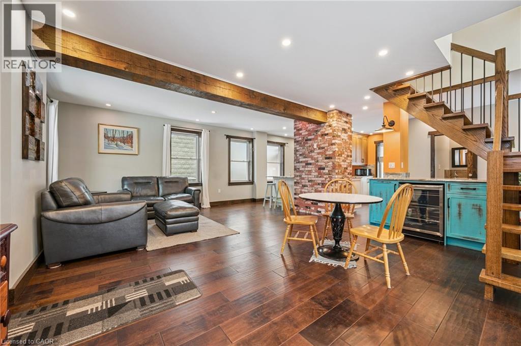 Open-concept living area featuring rich wood-finish flooring and exposed ceiling beams - 838 Moore Street, Cambridge, ON - Indoor