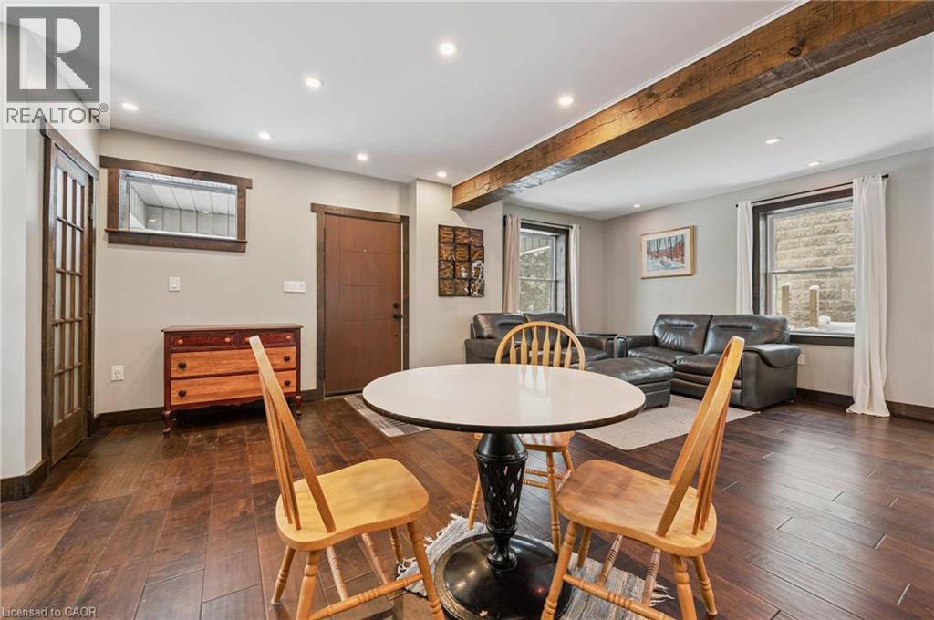 Open-concept living area featuring wood-finish flooring, exposed ceiling beams, recessed lighting, and dark wood trim throughout - 838 Moore Street, Cambridge, ON - Indoor Photo Showing Dining Room