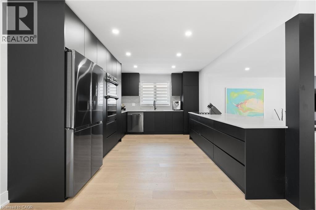 Kitchen with dark cabinets, modern cabinets, tasteful backsplash, recessed lighting, and stainless steel appliances - 17 Clearview Drive, Hamilton, ON - Indoor