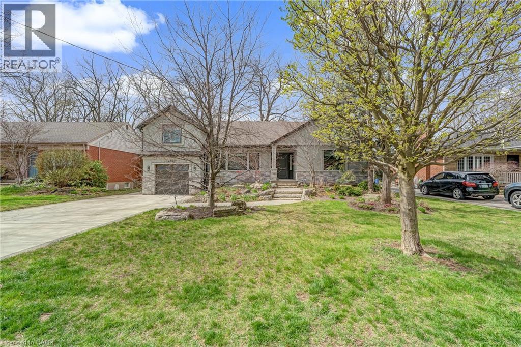 Stone facade residence featuring a front lawn and mature trees - 2123 Deyncourt Drive, Burlington, ON - Outdoor