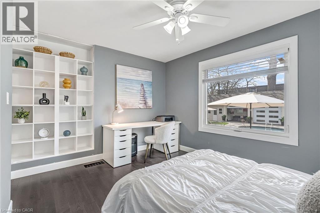 Spacious room featuring dark wood-finish flooring, a ceiling fan, and built-in shelving - 2123 Deyncourt Drive, Burlington, ON - Indoor Photo Showing Bedroom
