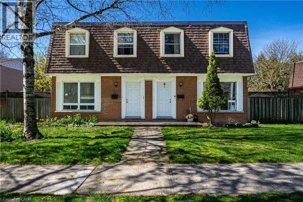 Brick exterior featuring a mansard roof, two dormer windows, and a manicured front lawn - 648 Francis Road, Burlington, ON - Outdoor