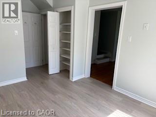 Light wood-finish flooring featuring a built-in shelving unit and bi-fold closet doors - 648 Francis Road, Burlington, ON - Indoor Photo Showing Other Room