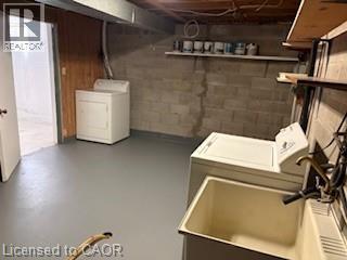 Dedicated laundry area featuring a utility sink with brass-finish faucet, concrete block walls, wood paneling, and painted concrete flooring - 648 Francis Road, Burlington, ON - Indoor Photo Showing Laundry Room