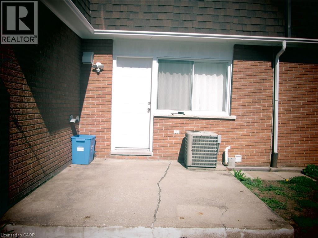 Brick exterior featuring a white entry door and a sliding window - 648 Francis Road, Burlington, ON - Outdoor With Exterior